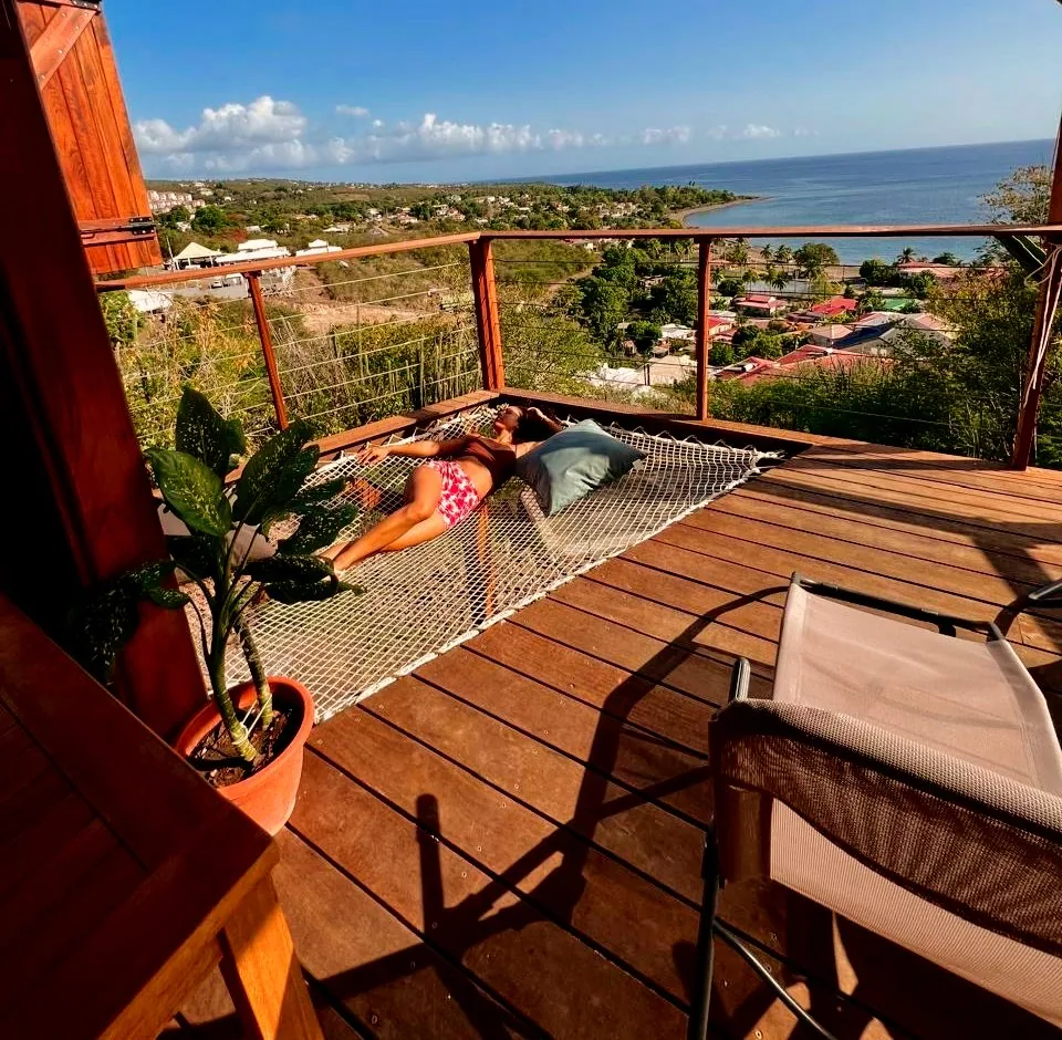 Vue extérieure du bungalow sur pilotis entouré de verdure tropicale