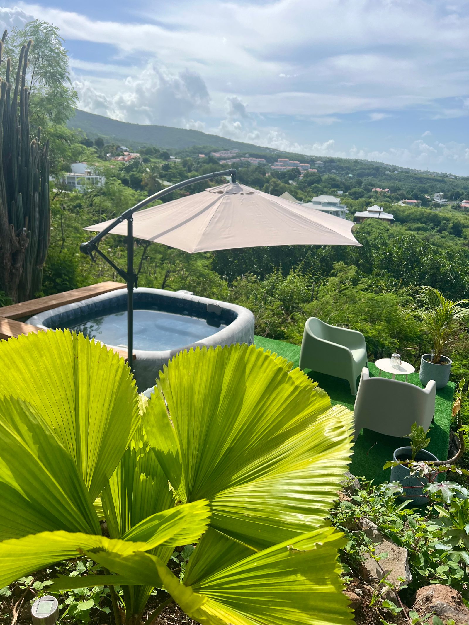 Jacuzzi avec salon de jardin et vue panoramique sur la mer de jour
