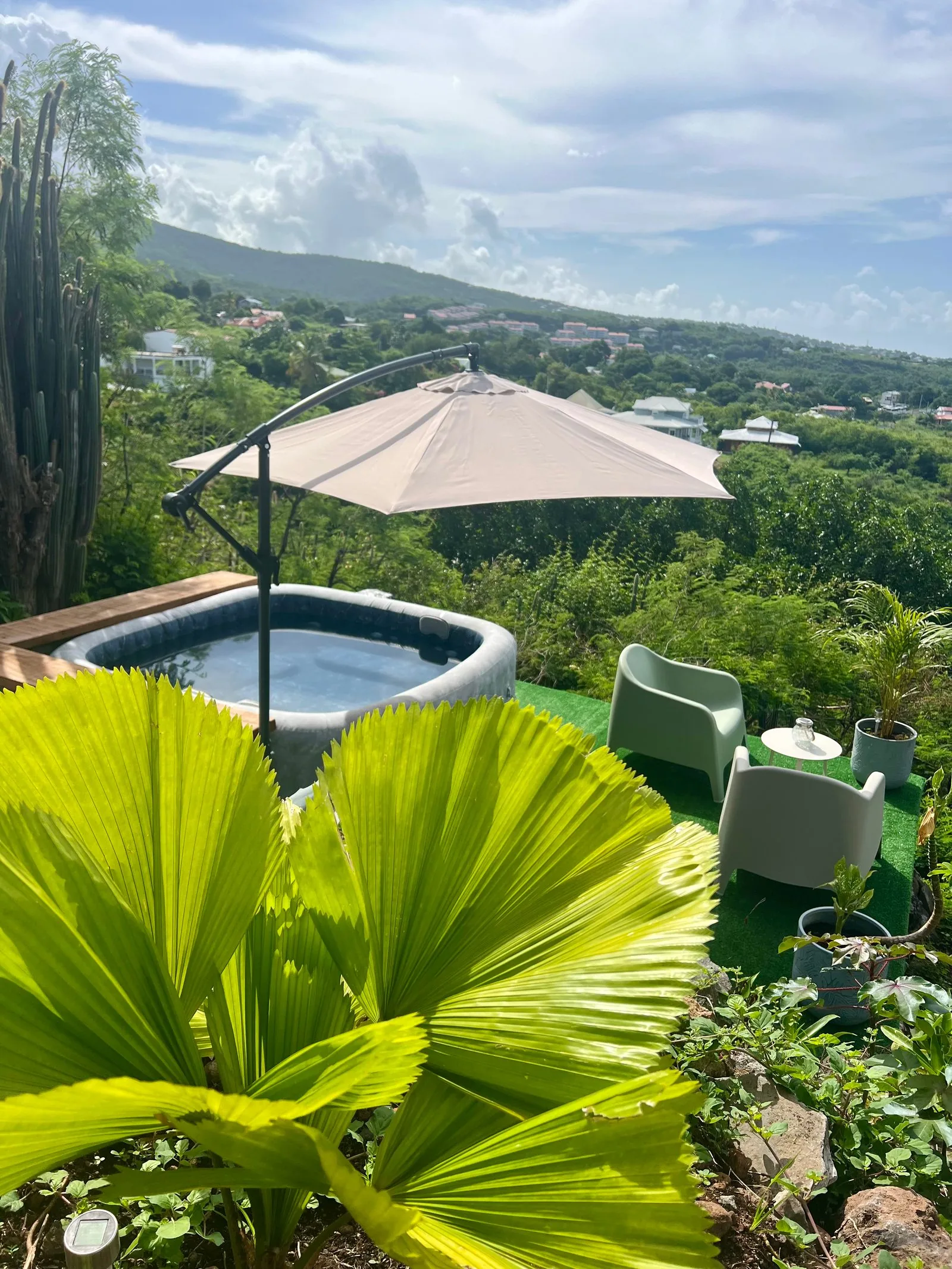 Jacuzzi avec salon de jardin et vue panoramique sur la mer de jour