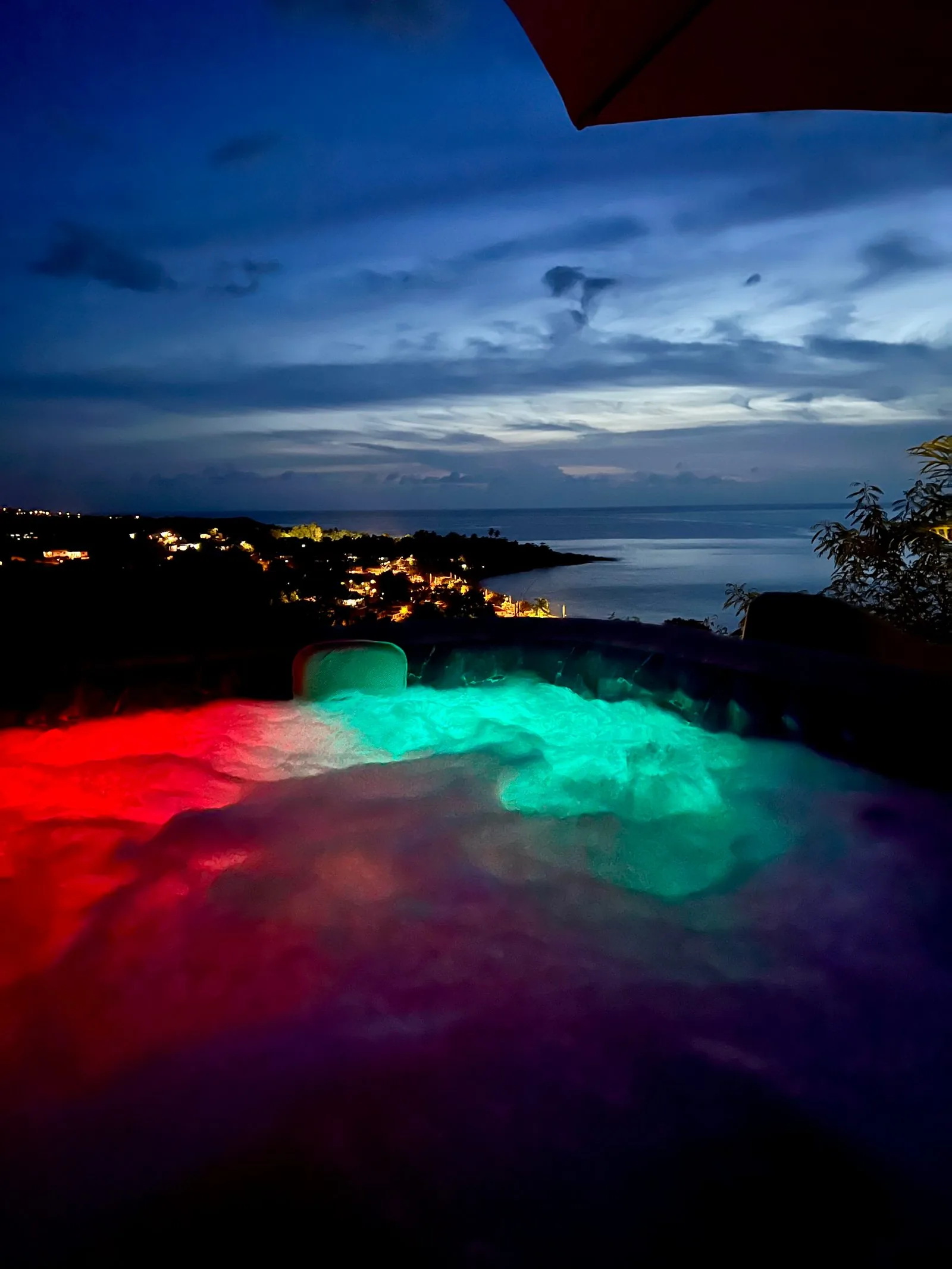Jacuzzi illuminé sous les étoiles en pleine nature tropicale
