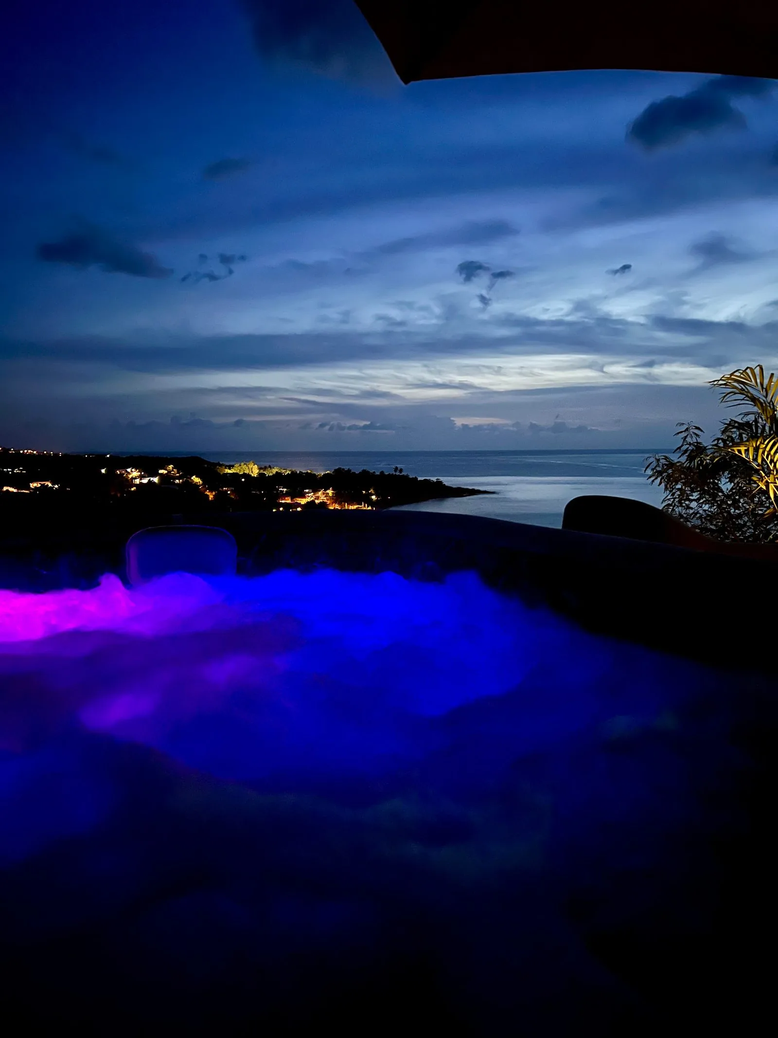 Jacuzzi privé avec éclairage bleu la nuit, vue sur la mer