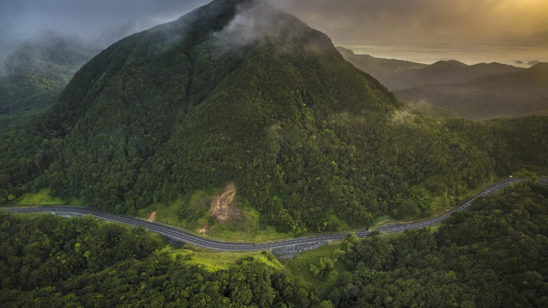 Vue aérienne de la Route de la Traversée serpentant à travers les montagnes forestières de Basse-Terre, Guadeloupe